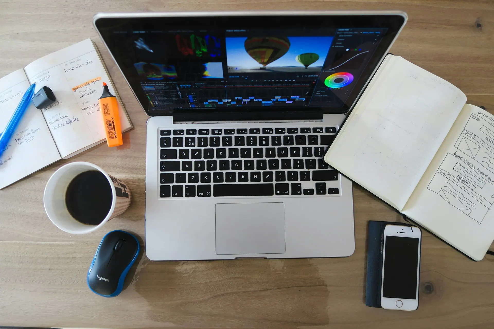 A planning desk with a notebook, contact sheet prints and a camera during creative preparation.