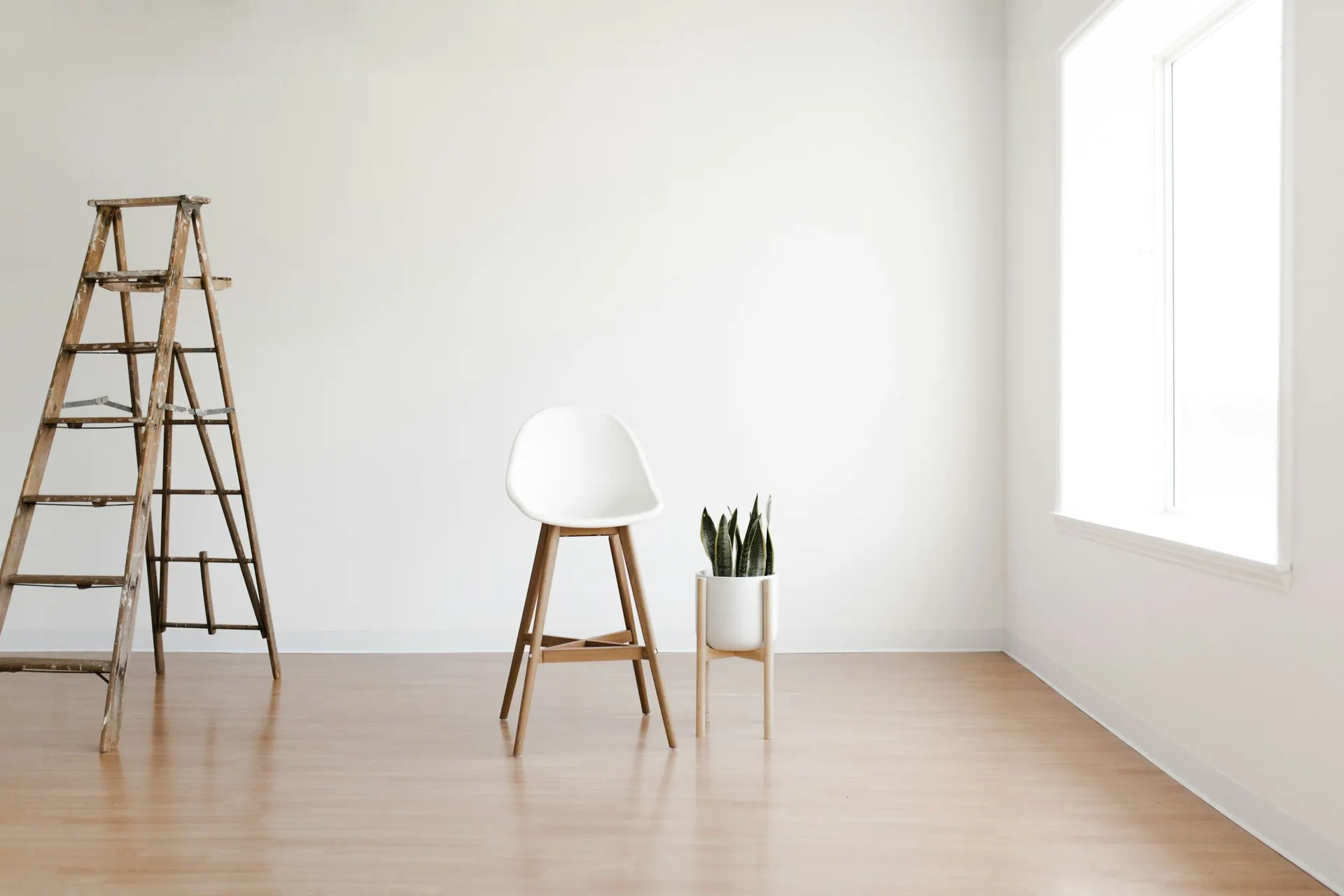 A minimal photography studio interior with neutral walls and a single light source.