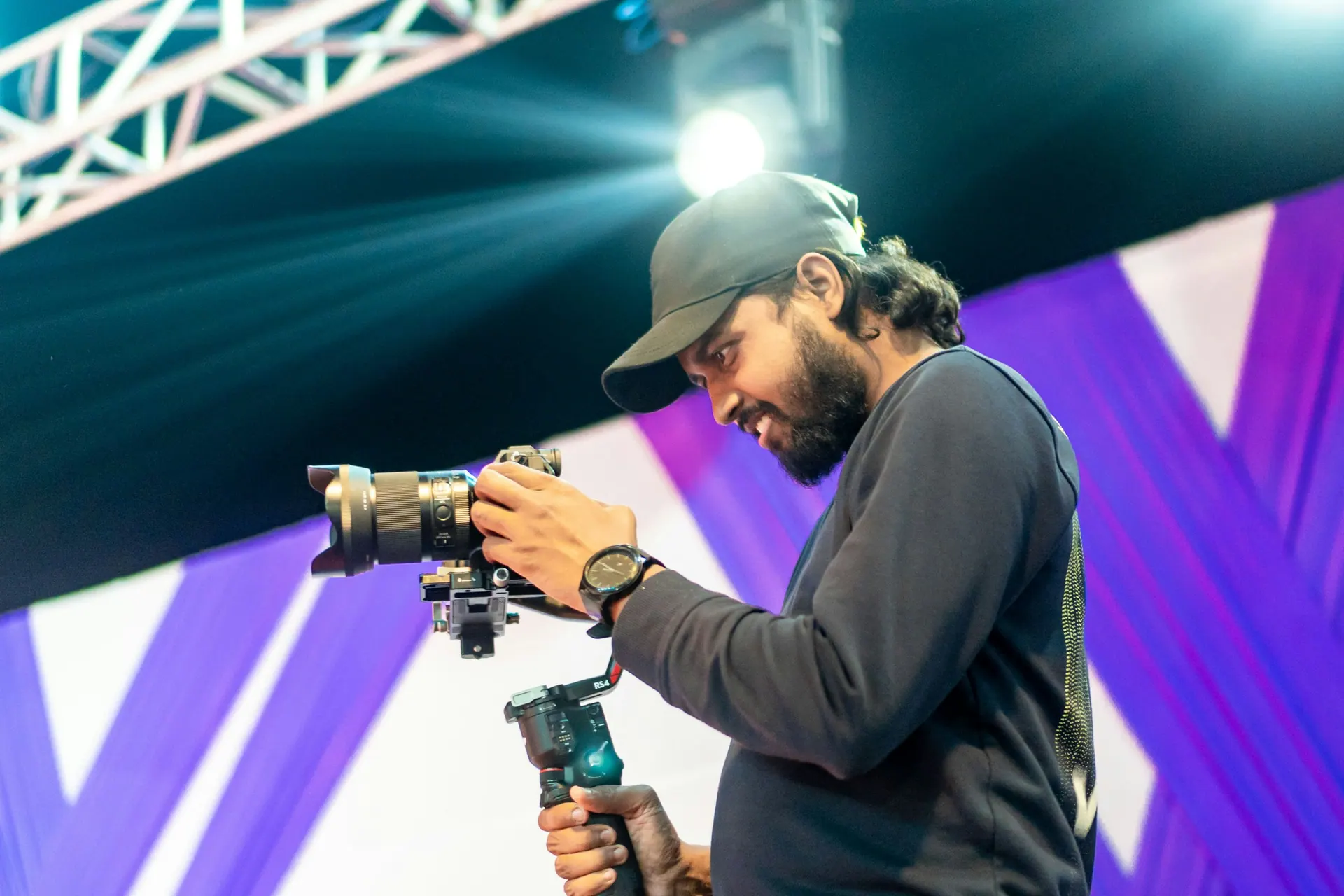 A photographer working with a camera in a low-light event environment.