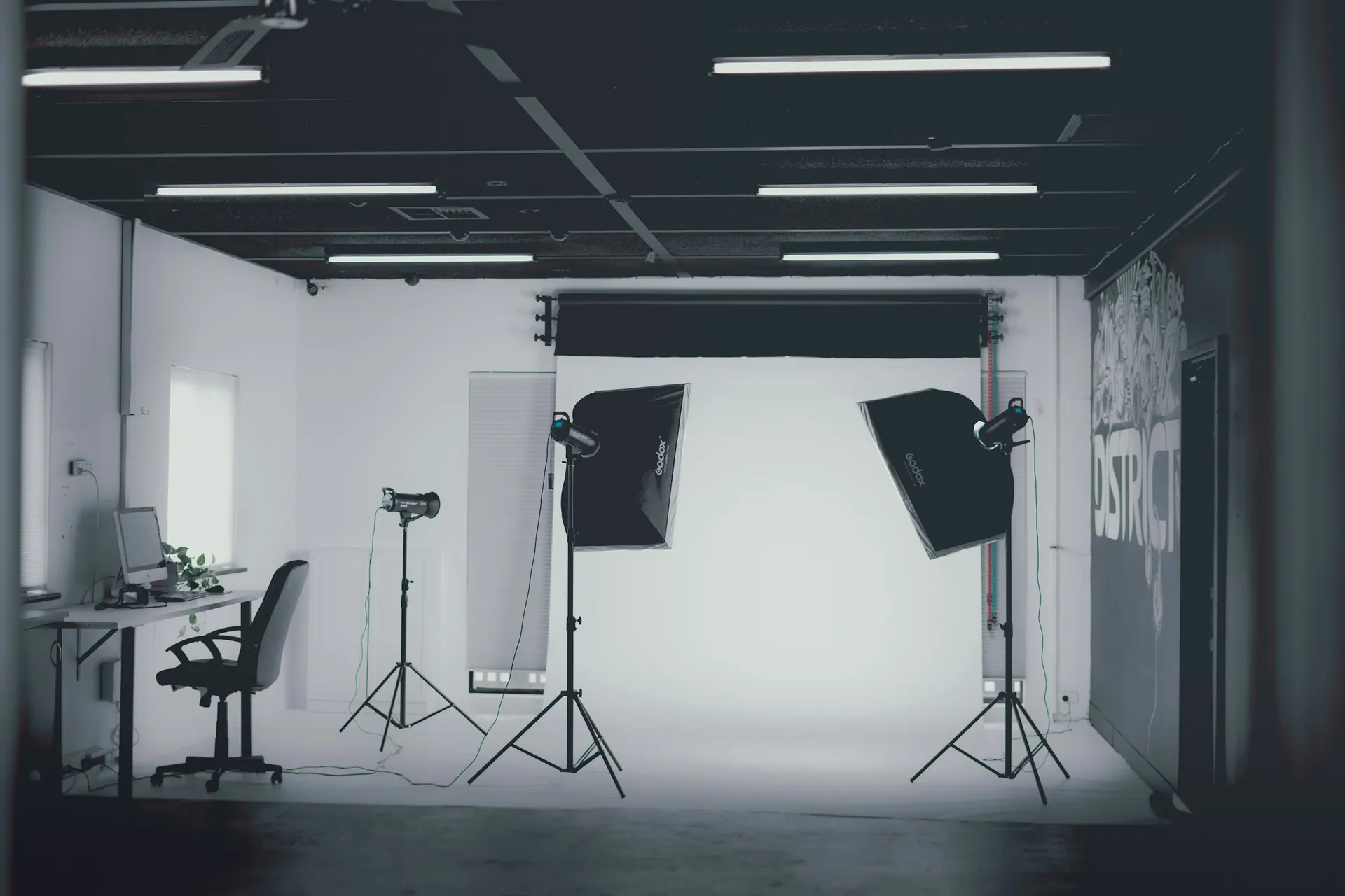 A photography studio with lighting stands, softboxes and a clear backdrop area.
