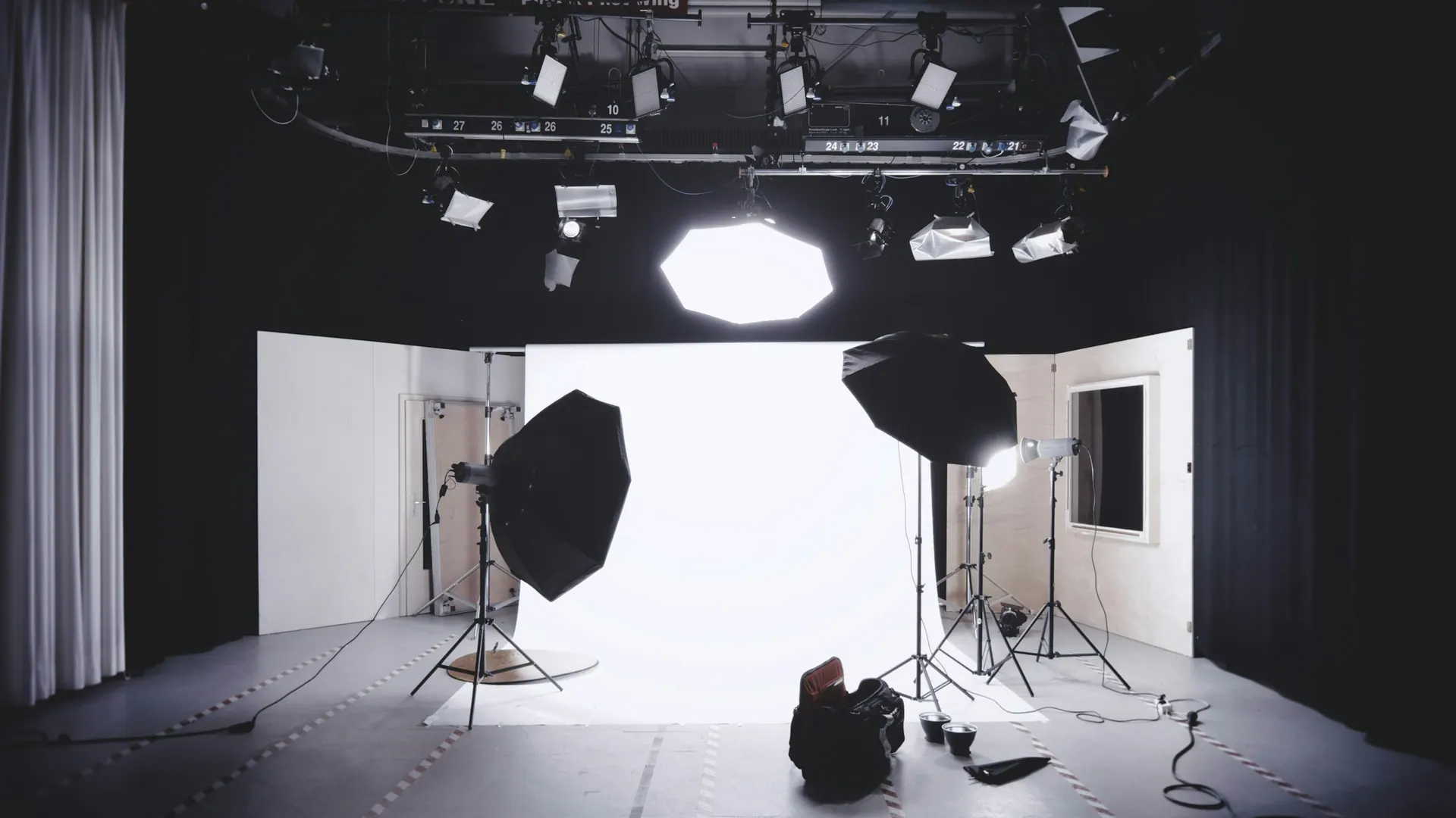 A professional camera body and lens resting on a workbench under soft directional studio light.