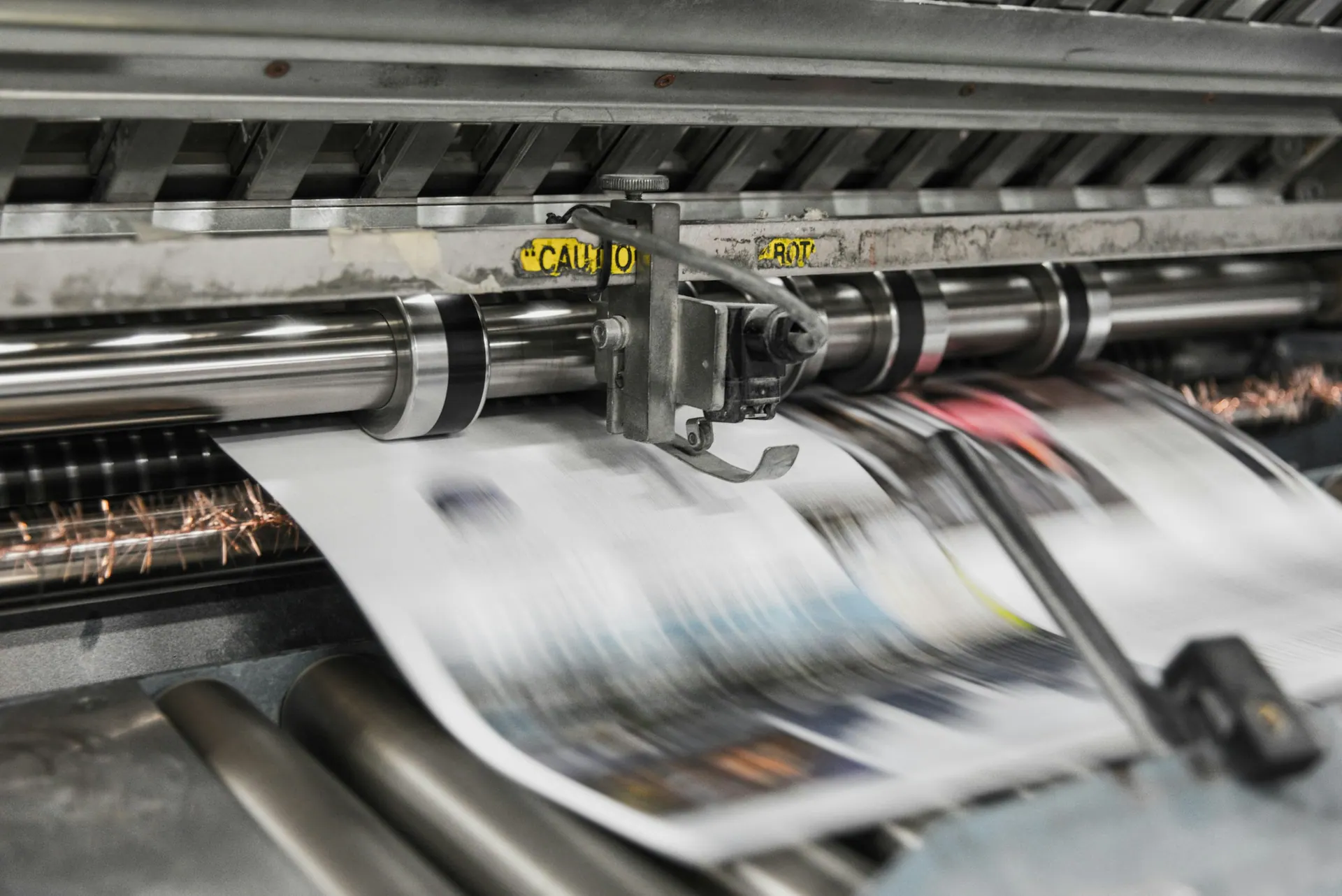 A large-format printer producing a photographic print on fine art paper.