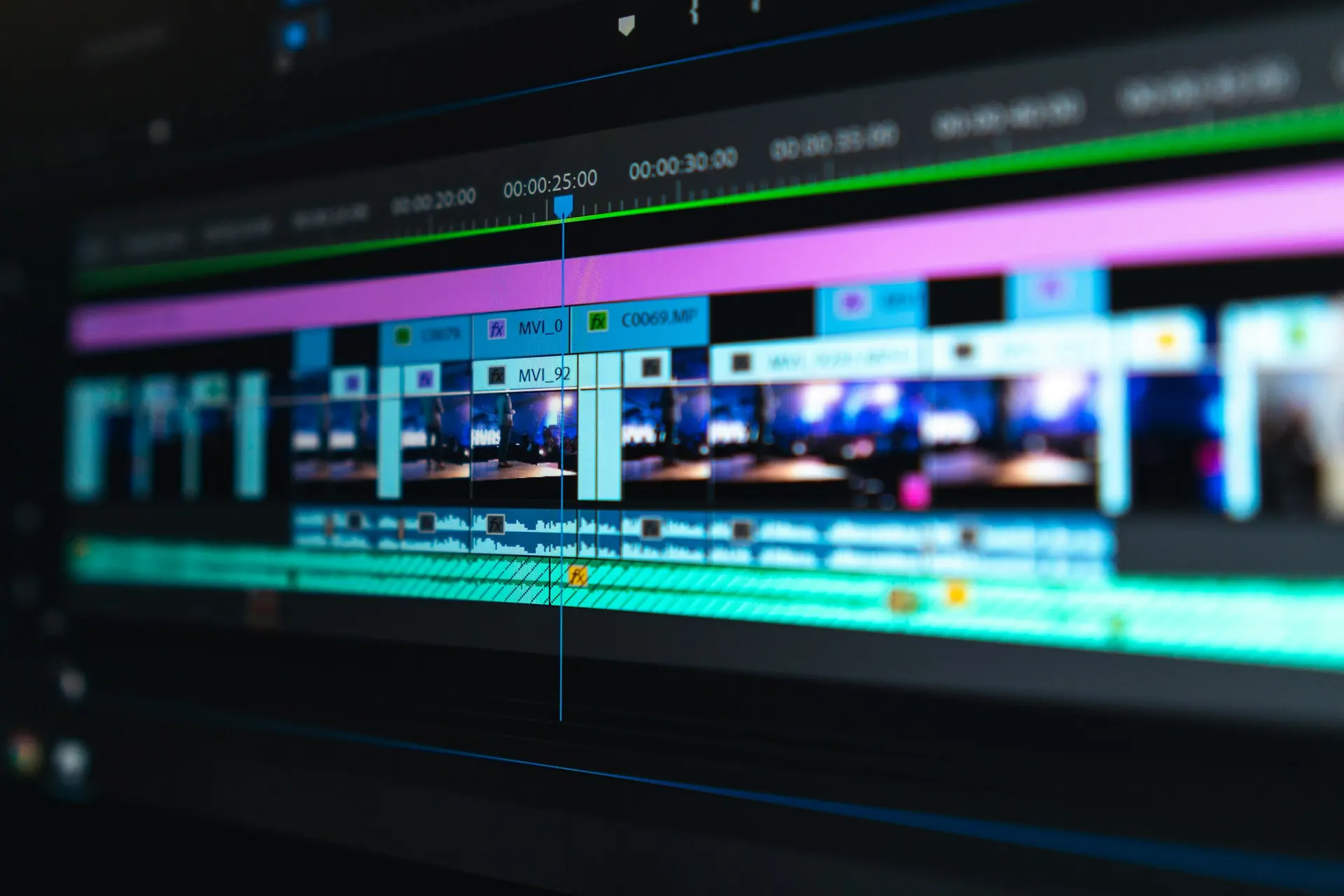 A video editing workstation with a timeline, preview window and audio waveforms on screen.
