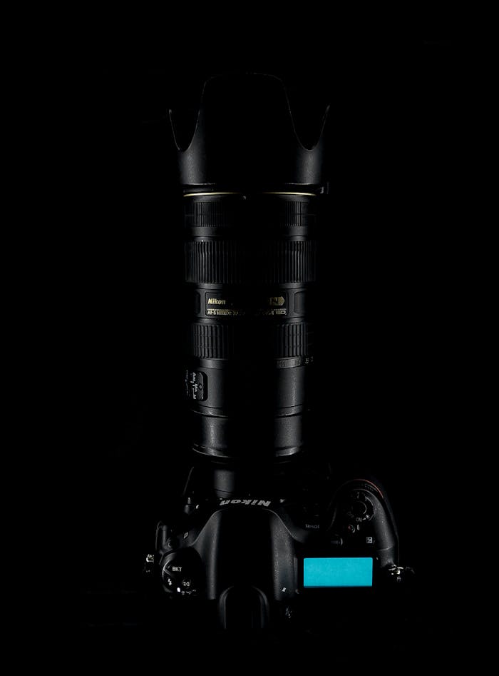 Close-up of a DSLR camera with lens against a dark background emphasizing professional photography equipment.